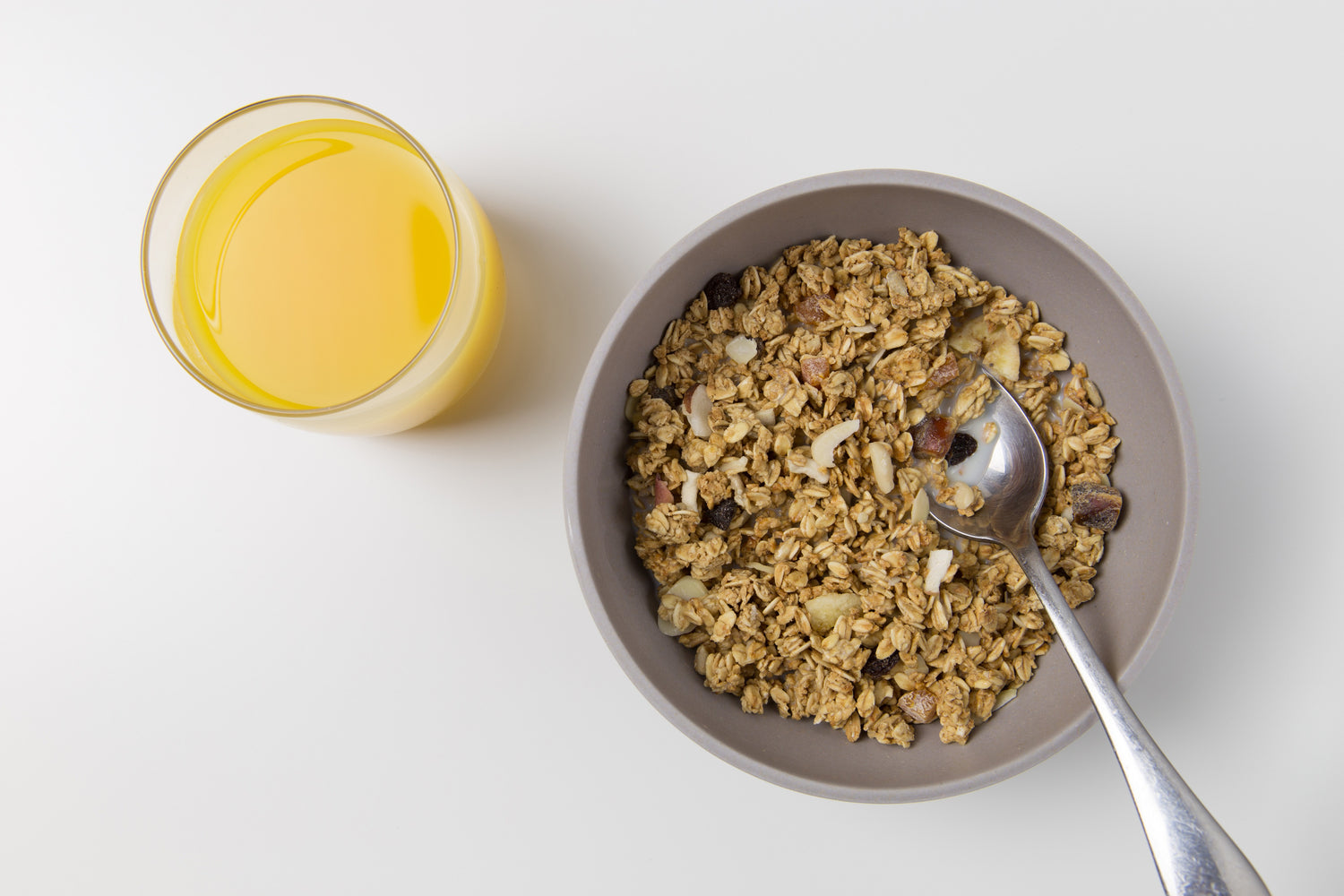 Morning oatmeal served with a site of orange juice.