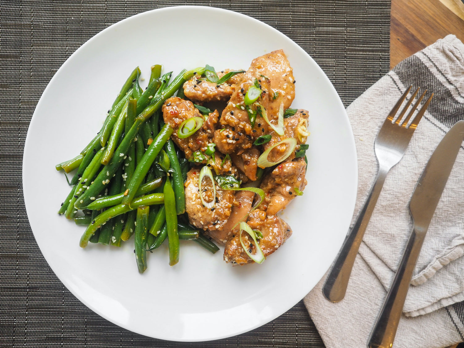 Pan fried chicken and collared greens sprinkled with sesame seeds.